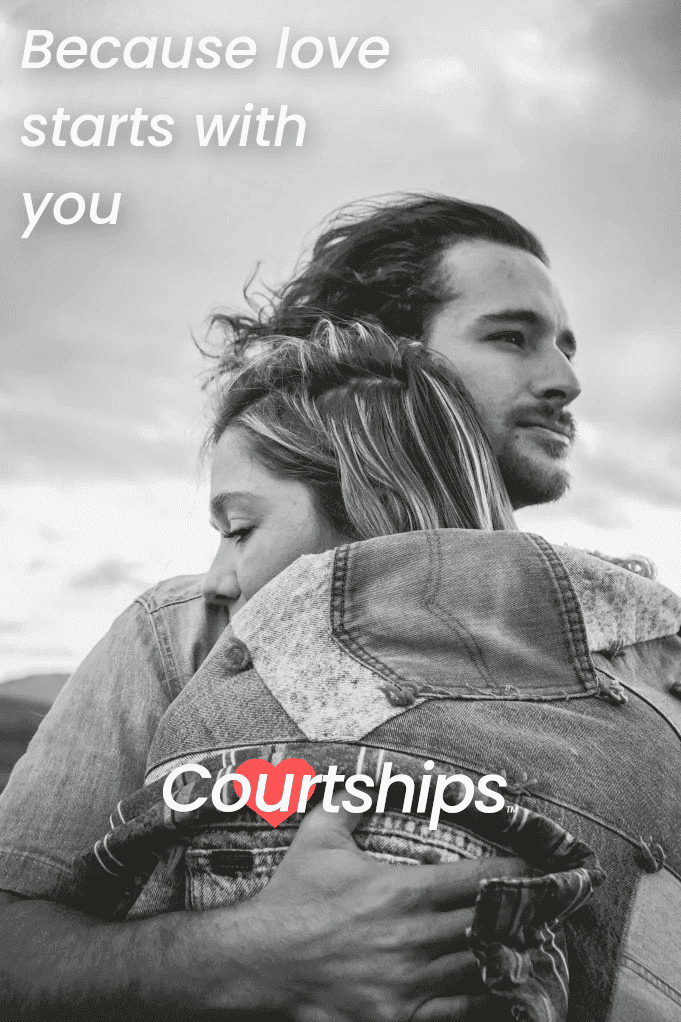 Young man and woman on the shoreline hugging and embracing