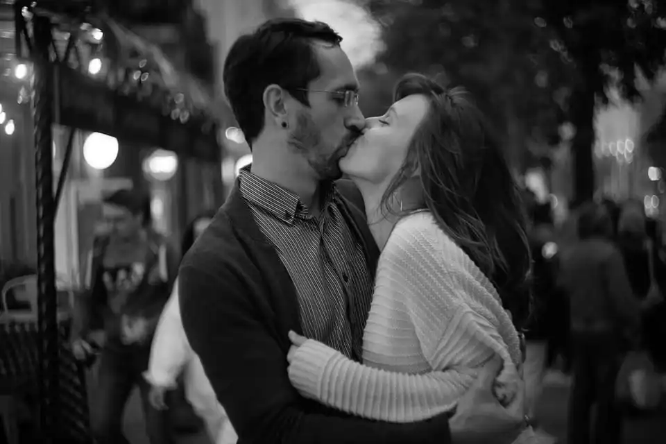 man and woman kissing at a event in the evening